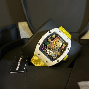 May include: A handmade, ceramic mug with a speckled, cream-colored glaze. The mug features a wide, rounded body and a sturdy handle. The interior is a darker, earthy tone. The mug is suitable for hot or cold beverages.