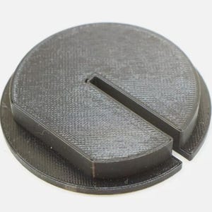 May include: A black plastic 3D printed base with a split design, ideal for creating a custom display stand.