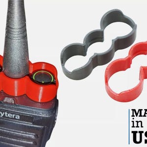 May include: Red and gray 3D printed radio antenna holders. The holders are designed to fit around the antenna and the radio's control knobs. The text "Hytera" is visible on the radio. The text "MADE in the USA" is visible on a white background with red and blue stripes.