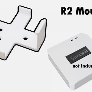 May include: White plastic wall mount for a Sonoff R2 smart switch. The mount is shaped like a cross with four arms. The text "Sonoff" and "not included" are visible on the switch, which is not included with the mount.