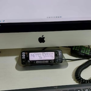 May include: A black handheld radio with a digital display showing the numbers "146770 439550". The radio has several buttons and a small antenna.