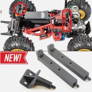 May include: A close-up of a black and gray 3D printed RC car chassis upgrade kit. The kit includes two long rods, a short rod, and a bracket. The kit is labeled "NEW!" in red.