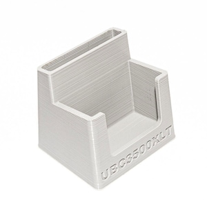 May include: A white plastic card holder with the text "UBCS3500XLT" printed on the front.