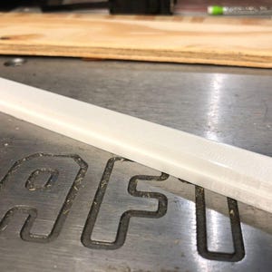 May include: A white plastic rectangular bar with a textured surface.