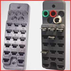 May include: A gray plastic fuse box with a clear plastic cover. The fuse box has 18 slots for fuses and is labeled with numbers and letters. The fuse box also has a label that says "45AR".