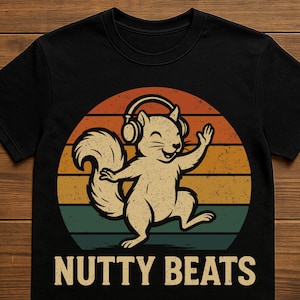 Könnte beinhalten: Schwarzes T-Shirt mit einem Cartoon-Eichhörnchen, das Kopfhörer trägt und tanzt. Das Design zeigt einen Retro-Sonnenuntergang mit orangefarbenen, gelben und grünen Streifen. Der Text "NUTTY BEATS" ist darunter gedruckt.