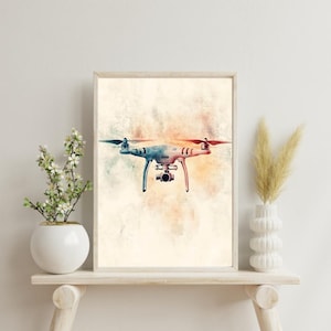 May include: A watercolour painting of a drone with a camera, set against a light beige background with splashes of orange and red.