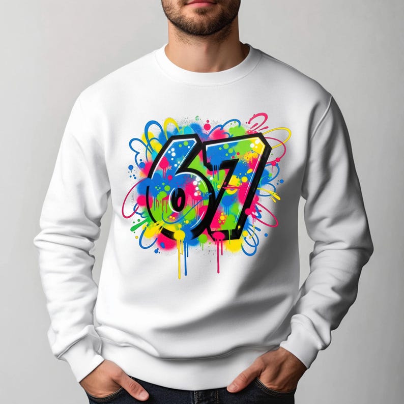 Pu&ograve; includere: Felpa bianca con un colorato design graffiti del numero 67. Il numero &egrave; delineato in nero con un gradiente verde e blu, circondato da spruzzi di vernice rosa, gialla e blu. Un capo unisex casual.