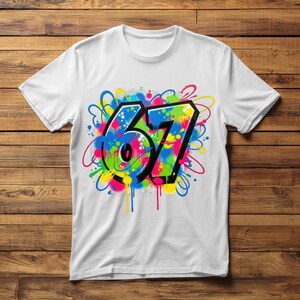 Pu&ograve; includere: T-shirt bianco con un design in stile graffiti del numero "67". Il design utilizza colori vivaci come blu, rosa, verde e giallo, con contorni neri e gocce di vernice. La maglietta &egrave; realizzata in un materiale morbido e confortevole.
