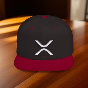 May include: A black and red baseball cap with a white "X" logo embroidered on the front.