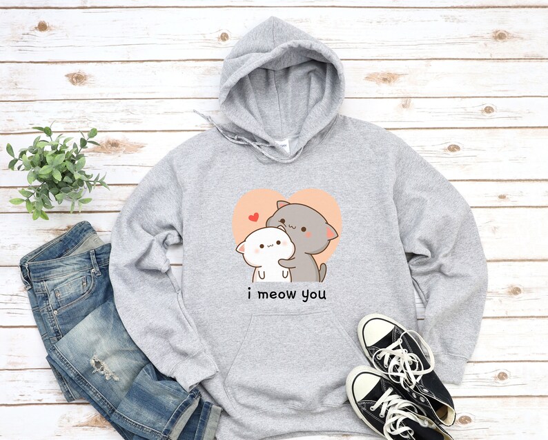 K&ouml;nnte beinhalten: Grauer Kapuzenpullover mit einem Motiv von zwei kuschelnden Comic-Katzen in einem Herzen. Der Text "i meow you" ist unter dem Motiv gedruckt.