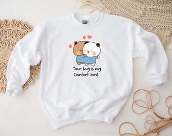 May include: White sweatshirt with a cartoon bear and panda hugging. The text "Your hug is my comfort zone" is printed below the image.