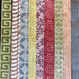 May include: A collection of ten rectangular paper strips with various patterns and colors. Designs include geometric shapes, floral patterns, and dotted textures. Colors range from green, brown, and blue to yellow, purple, and red.