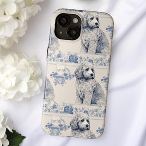 May include: A white iPhone case with a blue and white floral pattern and a repeated image of a white dog with brown eyes.