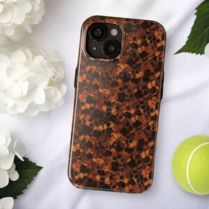 May include: A brown and orange phone case with a mottled pattern. The case is designed to fit an iPhone.