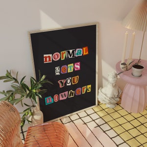 Puede incluir: Un p&oacute;ster enmarcado en negro con las palabras "normal gets you nowhere" en letras recortadas de colores. El p&oacute;ster est&aacute; colgado en una pared blanca.