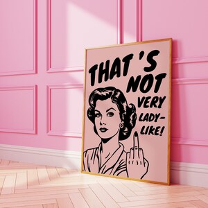 K&ouml;nnte beinhalten: Ein rosa und schwarzes Poster mit einer Retro-Illustration einer Frau, die den Mittelfinger zeigt. Der Text auf dem Poster lautet "That's not very lady-like!"