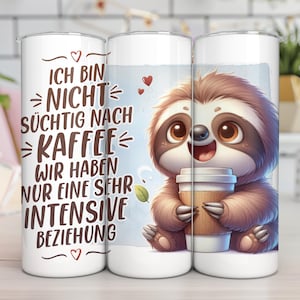 May include: White tumbler with a cartoon sloth holding a coffee cup. The tumbler has the text "ICH BIN NICHT S&Uuml;CHTIG NACH KAFFEE WIR HABEN NUR EINE SEHR INTENSIVE BEZIEHUNG" in black. The sloth is brown and has big brown eyes.