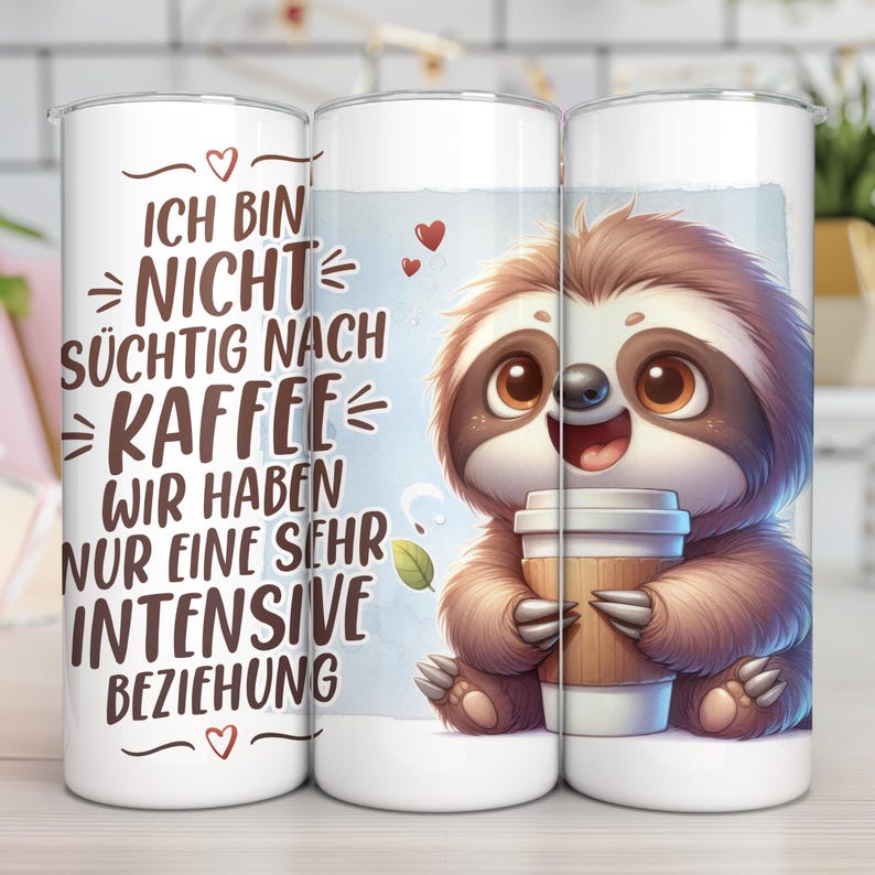 May include: White tumbler with a cartoon sloth holding a coffee cup. The tumbler has the text "ICH BIN NICHT S&Uuml;CHTIG NACH KAFFEE WIR HABEN NUR EINE SEHR INTENSIVE BEZIEHUNG" in black. The sloth is brown and has big brown eyes.