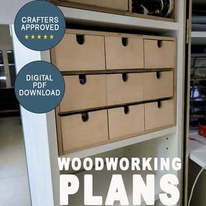 May include: A set of nine wooden drawers in a white cabinet. The drawers are unfinished and have a natural wood color. The cabinet is labeled "WOODWORKING PLANS" and has a sticker that says "CRAFTERS APPROVED" with five stars.