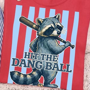 Colpisci la palla PNG, clipart divertente di un procione che gioca a softball, torneo di softball itinerante PNG, design per maglietta da mamma di una giocatrice di softball, sport con procioni PNG