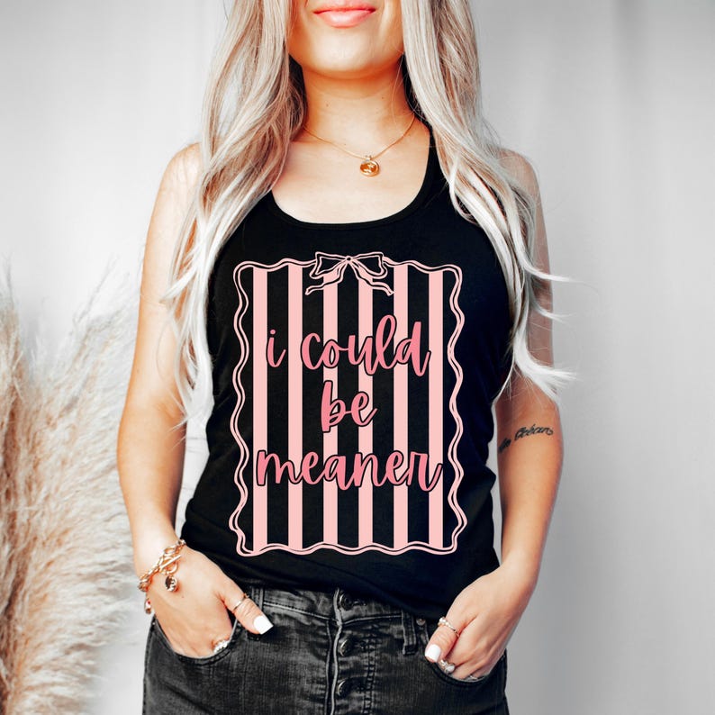 May include: Black tank top with a pink and white striped design and the text "I could be meaner". The text is in a pink, cursive font. The tank top is sleeveless.