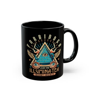 Op de afbeelding: Zwarte keramische mok met een afbeelding van een piramide met een alziend oog, een theepot en twee theekopjes. De tekst luidt "Forbidden", "Join the Illumina-Tea Secret Society" en "17" en "76".