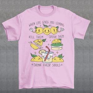 Introducing our adorable and quirky Lemonade-themed t-shirt that is sure to turn heads and bring a smile to your face! This shirt features a delightful design showcasing cute lemons being transformed into delicious lemonade, accompanied by the bold, tongue-in-cheek text: "WHEN LIFE GIVES YOU LEMONS, KILL THEM, CRUSH THEM AND DRINK THEIR SOULS."