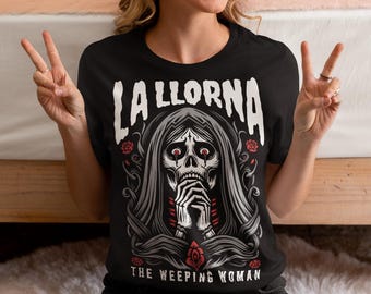 Könnte beinhalten: Schwarzes T-Shirt mit einem weißen Grafikdruck einer Frau mit einem Schädelgesicht und dem Text "La Llorna The Weeping Woman".