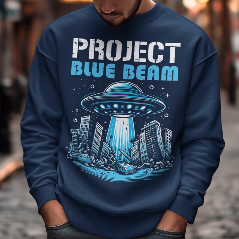 This bold and striking sweatshirt features a dramatic scene of a UFO hovering menacingly above a futuristic city, casting a glowing beam of light that tears through skyscrapers, causing chaos and destruction below. The detailed artwork captures the intensity of the moment, with crumbling buildings giving the design an apocalyptic feel. Above the imagery, the text "PROJECT BLUE BEAM" is emblazoned in bold, futuristic typography, adding a mysterious and conspiracy-driven edge to the design.