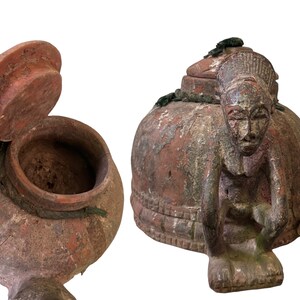 May include: Two terracotta pottery jars with lids. One jar features a carved human figure on the lid. Both jars have a rustic, aged appearance.