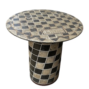 May include: A black and white checkered ceramic side table with a round top and a cylindrical base. The top has a geometric design around the edge and a rectangular design in the center.