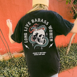 May include: Black t-shirt featuring a graphic of a skull and snake with the text "Long Live Badass Women" and "Doin' it Better Since Day One".