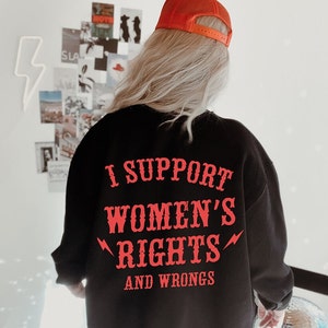 May include: Black sweatshirt with red text that reads "I support women's rights and wrongs".