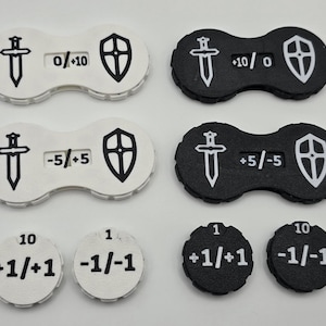 Könnte beinhalten: Satz von acht schwarzen und weißen Spielsteinen aus Kunststoff mit einem Schwert- und Schild-Design. Die Steine ​​haben verschiedene Zahlen und Symbole aufgedruckt, darunter "0/+10", "+10/0", "-5/+5", "+5/-5", "1", "10", "+1/+1" und "-1/-1".