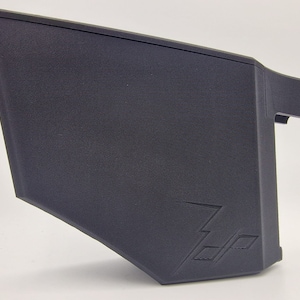 May include: A black plastic storage container with a textured surface and a lightning bolt logo. The container is designed for storing small items.