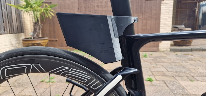 May include: A black bicycle with a black and white rear wheel and a black fender attached to the seat post. The fender has the word "700" printed on it.