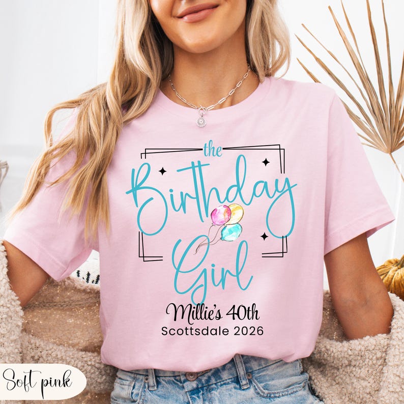 Puede incluir: Camiseta rosa claro con la frase "the Birthday Girl" en turquesa, con globos. Debajo, se lee "Millie's 40th Scottsdale 2026". La camiseta es de color rosa claro.