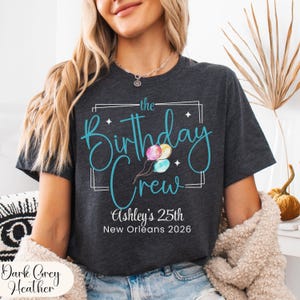 Puede incluir: Camiseta gris oscuro jaspeado con el texto "the Birthday Crew" en turquesa, con globos de acuarela. La camiseta tambi&eacute;n incluye "Ashley's 25th New Orleans 2026".