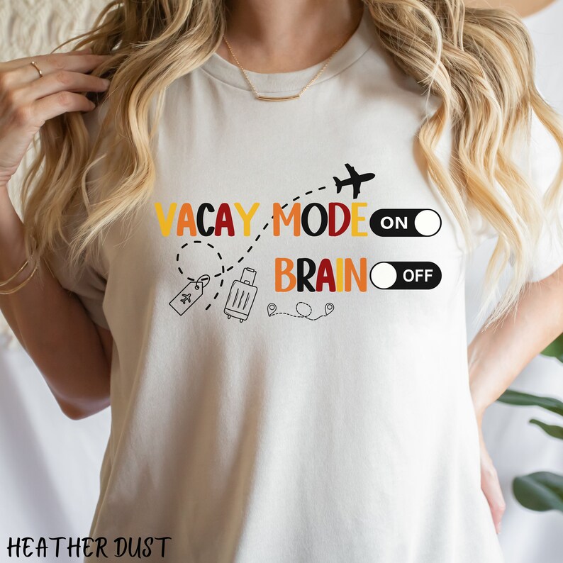 May include: White t-shirt with a graphic design that says "Vacay Mode On" and "Brain Off" with a plane, suitcase, and location pins.