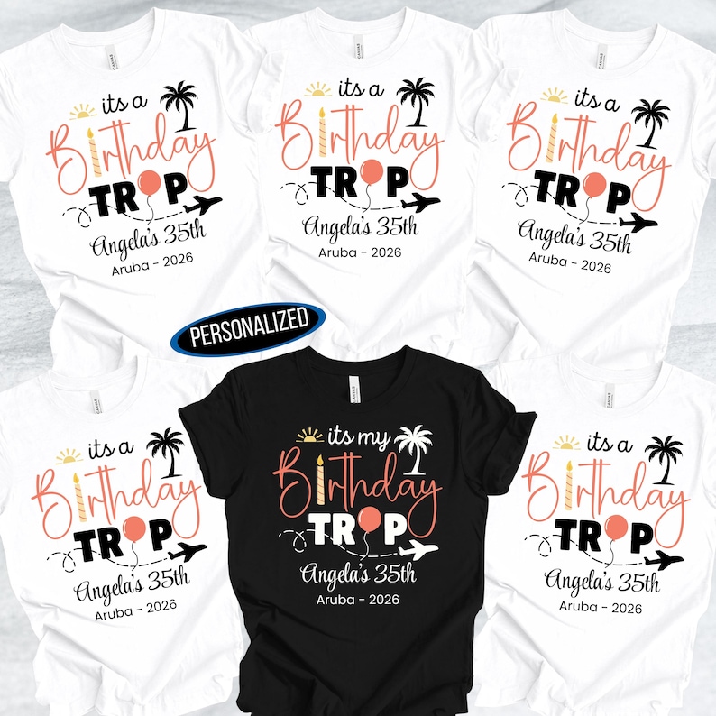 May include: White and black t-shirts with a birthday travel theme. The shirts feature the text "its a Birthday Trip" with a palm tree, airplane, and balloon graphic. The text "Angela's 35th Aruba - 2026" is also included.