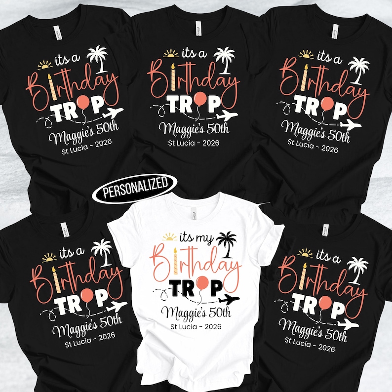 May include: A collection of black and white t-shirts with a birthday theme. The shirts feature the text "its a Birthday TROP" with a palm tree, airplane, and balloon graphic. The text "Maggie's 50th St Lucia - 2026" is also included.