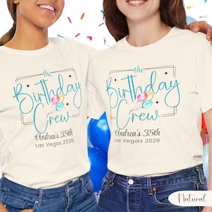 Puede incluir: Dos camisetas color crema con el texto "the Birthday Crew" en escritura turquesa, con globos y el texto "Andrea's 35th Las Vegas 2026". Las camisetas se combinan con vaqueros azules.