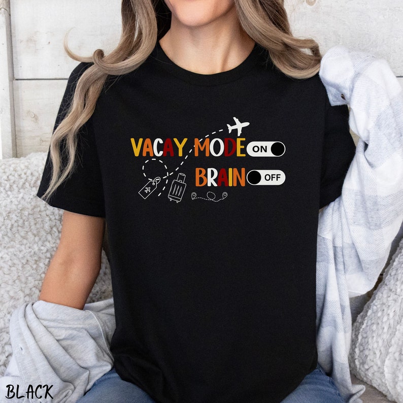 May include: Black t-shirt with a graphic design that says "Vacay Mode On" and "Brain Off" with a plane, suitcase, and luggage tag.