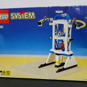 Puede incluir: Un set de Lego System con una estaci&oacute;n espacial blanca y azul con un brazo de gr&uacute;a amarillo. La caja es azul y blanca con el logotipo de Lego System y el n&uacute;mero de set 6456. La caja tambi&eacute;n dice 8-12 a&ntilde;os.