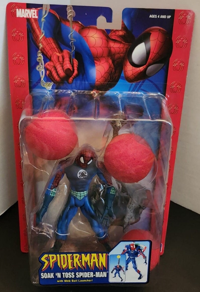May include: A blue and red Spiderman action figure with a web-ball launcher. The figure is holding two red foam balls. The packaging is red and features a cartoon image of Spiderman.