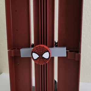 Peut inclure: Bo&icirc;te de rangement rouge et noire sur le th&egrave;me de Spider-Man. La bo&icirc;te a une conception &agrave; charni&egrave;re avec un embl&egrave;me Spider-Man sur le devant. La bo&icirc;te est en plastique et de forme rectangulaire.