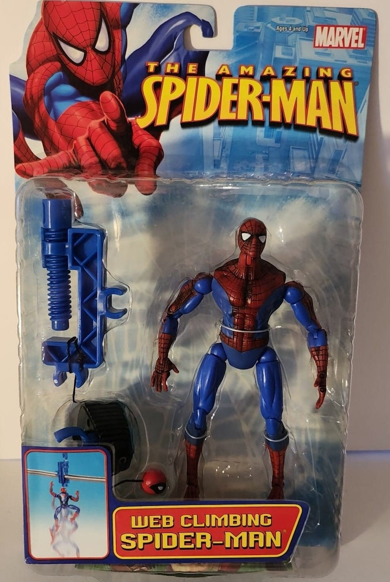 Pode incluir: Uma figura de a&ccedil;&atilde;o do Homem-Aranha vermelha e azul com um acess&oacute;rio de arremesso de teia. A figura &eacute; embalada em uma embalagem blister de pl&aacute;stico com fundo azul e vermelho. A embalagem apresenta o logotipo da Marvel e o texto "The Amazing Spider-Man".