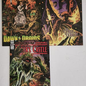 May include: Three Star Wars Adventures comic books. The covers feature illustrations of characters and scenes from the Star Wars universe. The comics have titles like "Ghosts of Vader's Castle" and "Dawn of Droids". The comic books are numbered 1, 2, and 3.