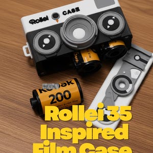 May include: A white and black film case designed to resemble a vintage camera, featuring the text Rollei CASE. The case includes a slot for a yellow Kodak 200 film roll. A separate white and gray rectangular component with circular details is included.